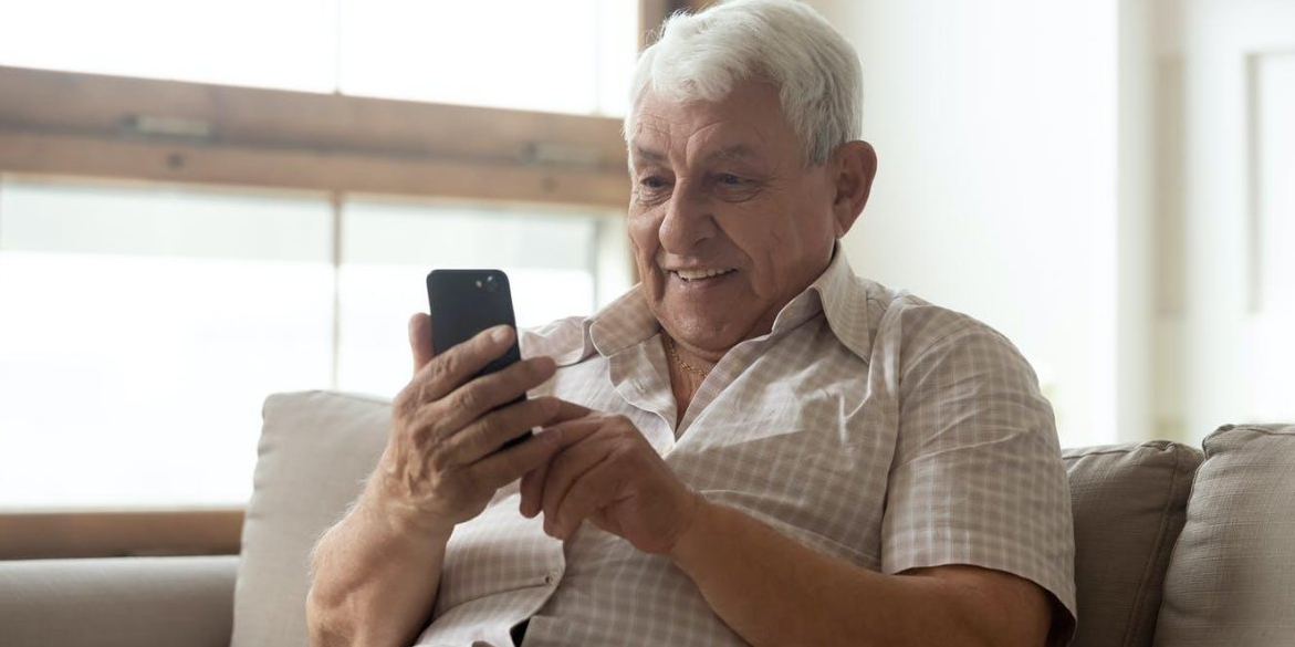 Elderly man checking cell phone