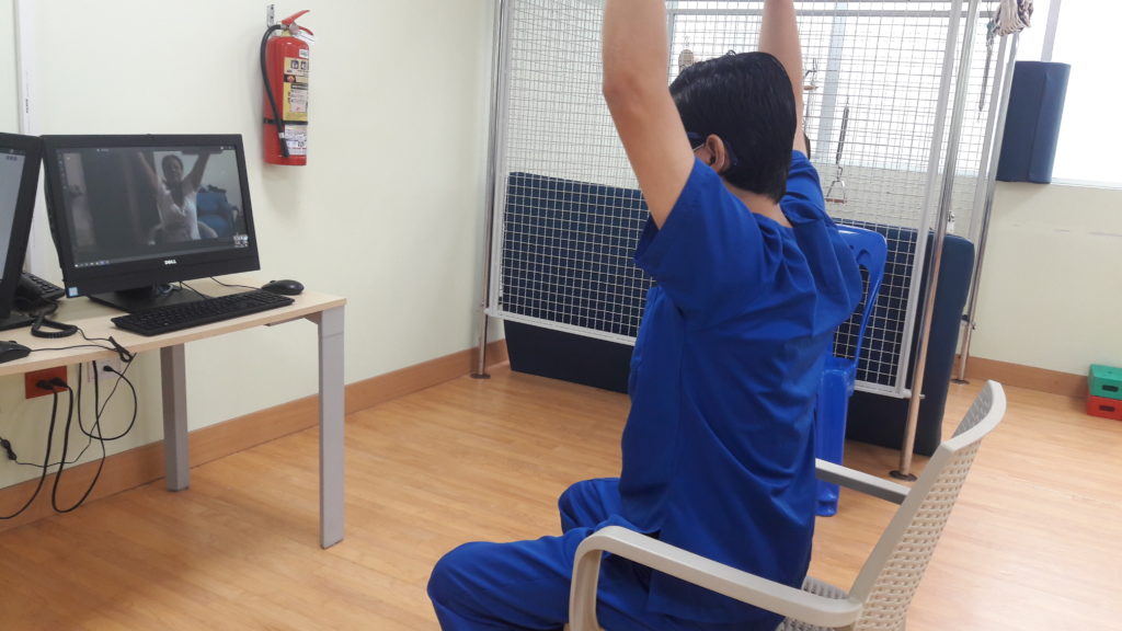 Person doing exercise with instructor on screen